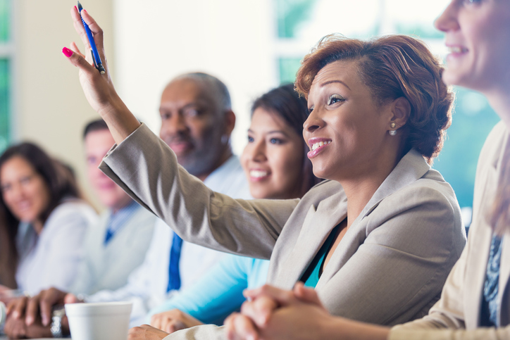 a businesswoman raising hand in a conference