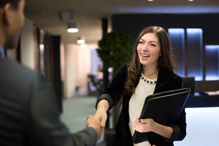 young woman shakes hands to a new business deal