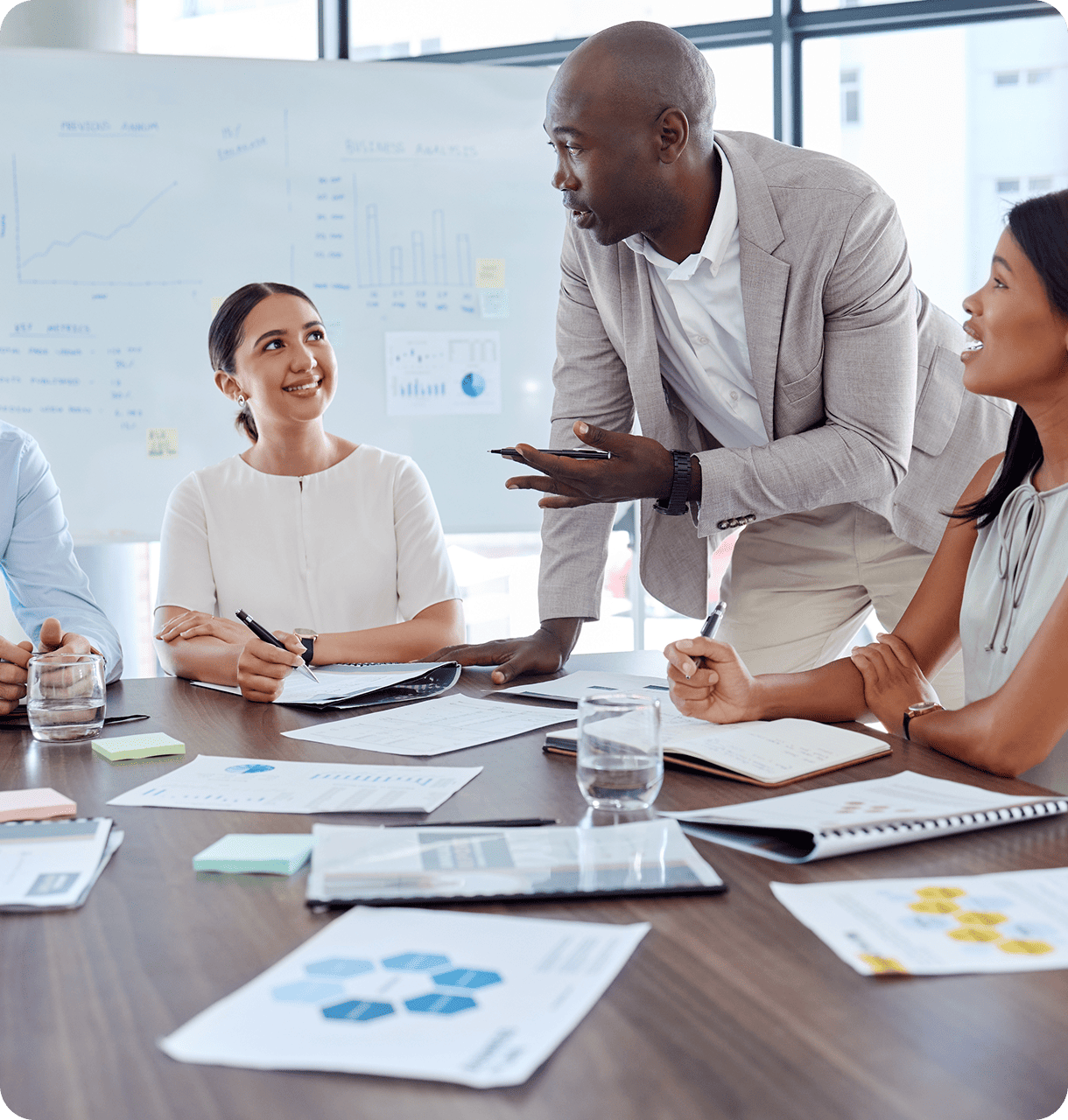 Team of franchise consultants collaborating over business documents, planning the franchising strategy for a growing company.