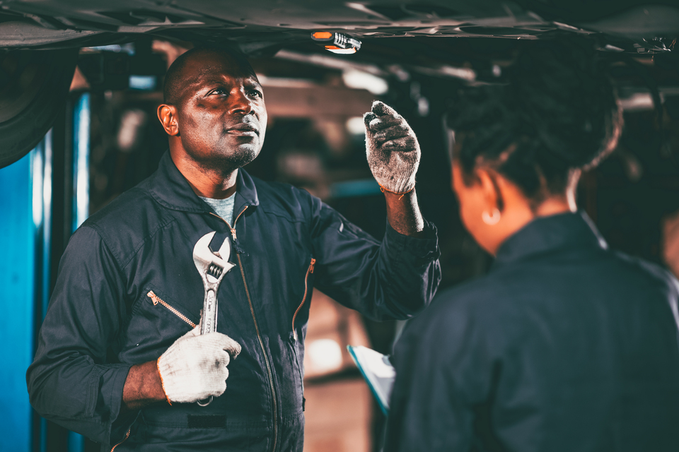 Technicians servicing vehicles in a busy auto garage, showcasing a streamlined operation ideal for an automotive repair franchise.