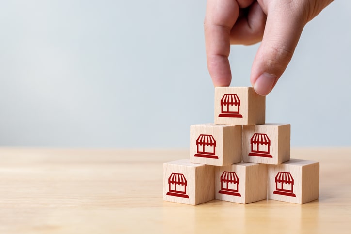 A hand stacking wooden blocks