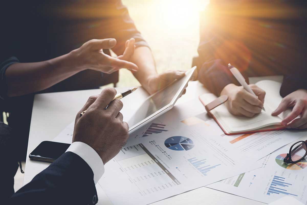 Three individuals engage in a business discussion